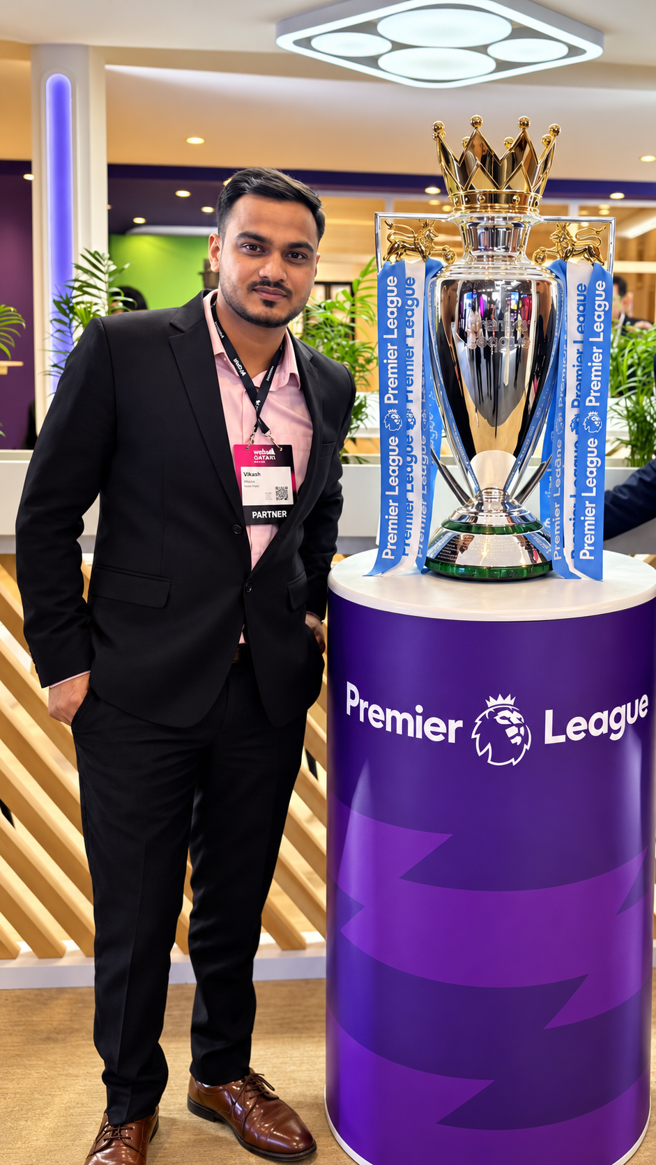 Vikash Kumar Sharma at a professional event beside the Premier League trophy